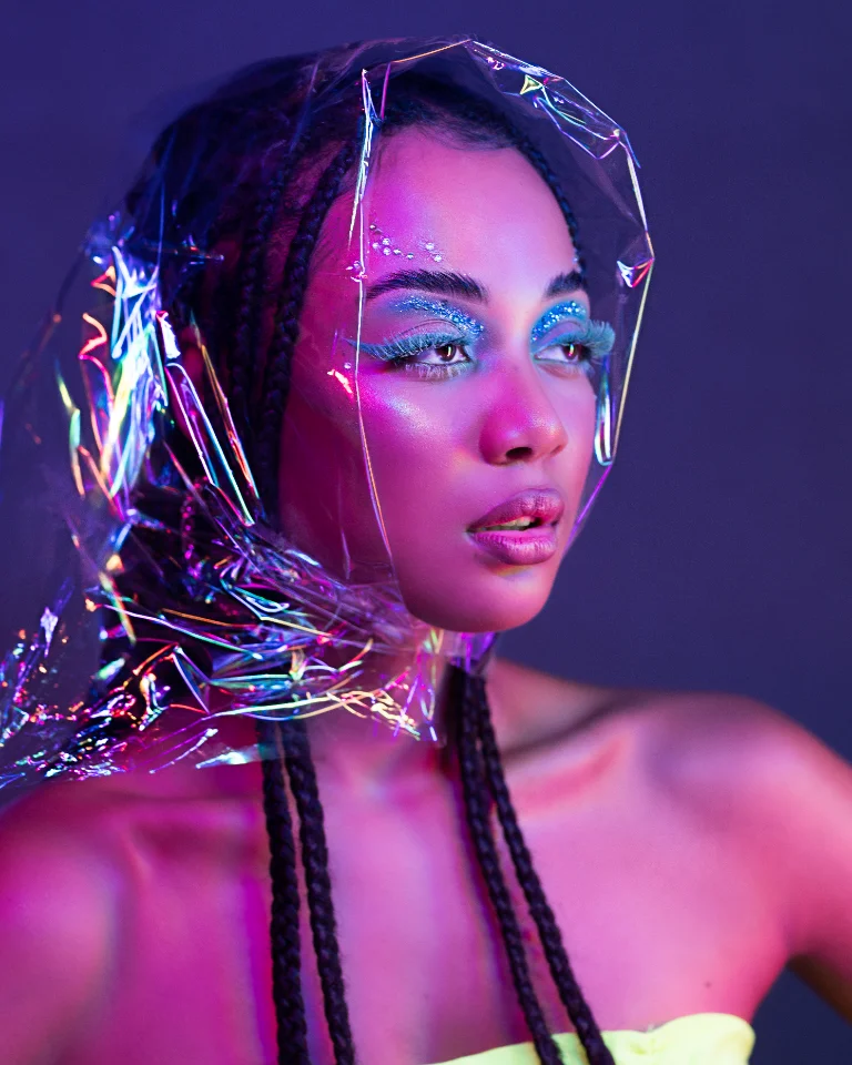 Beauty portrait in iridescent film under neon lighting